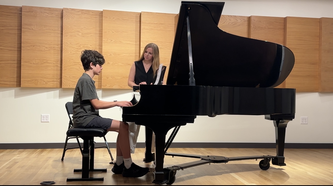 Anna teaching a student at a grand piano