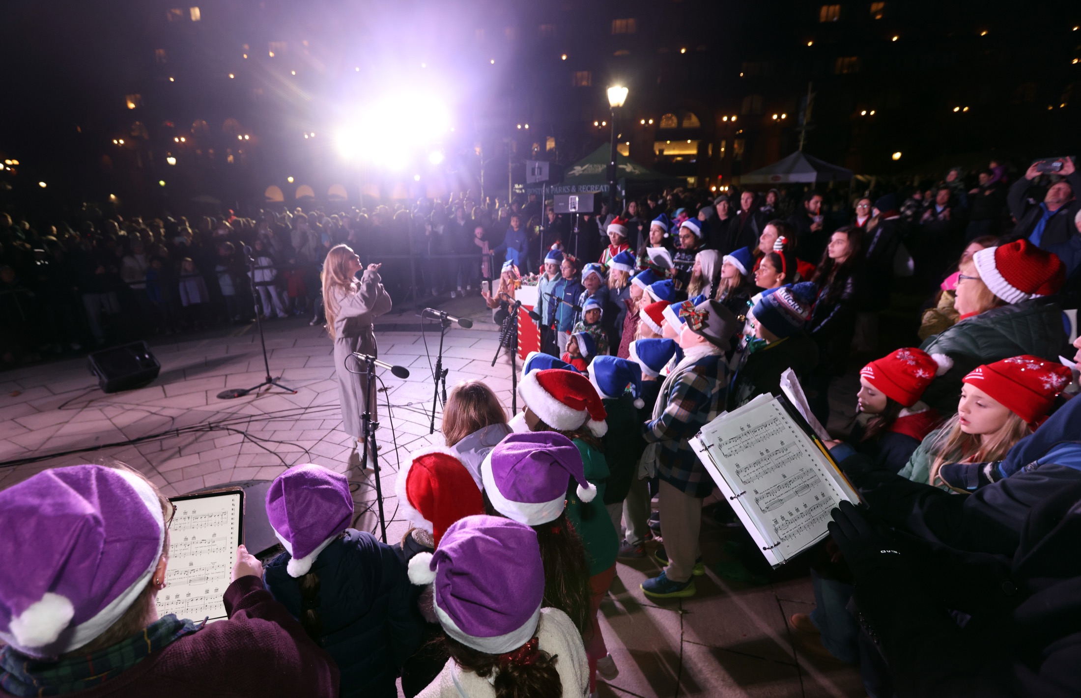 Anna conducting a community holiday choir at an outdoor Boston mayoral event